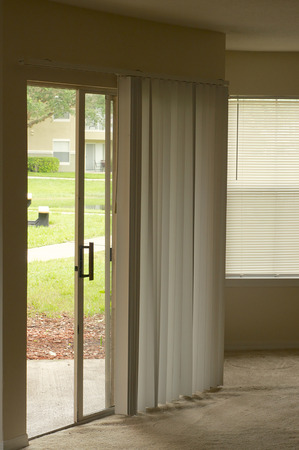 Sliding glass door with vertical blinds.